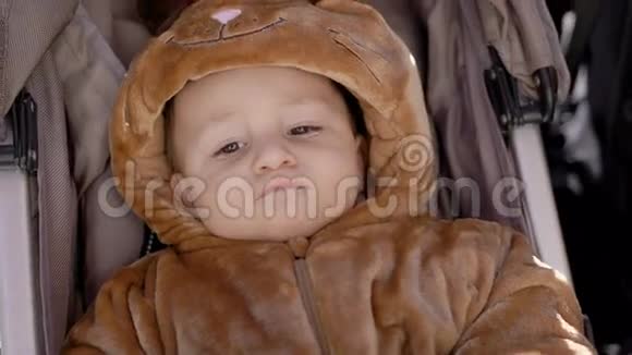 穿着服装的婴儿躺在公园的马车里视频的预览图
