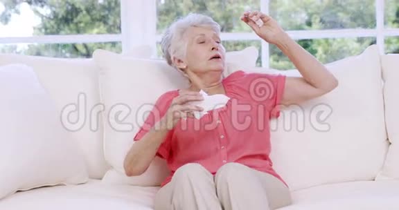 年长的女人在沙发上哭泣视频的预览图