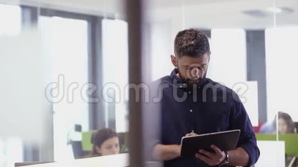 在办公室里使用平板电脑时商人微笑着拍照视频的预览图