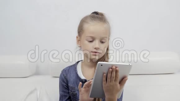 教育学校技术和互联网概念在学校或家里带平板电脑的小学生女孩做家庭作业视频的预览图