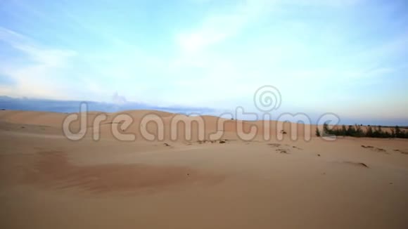 日落时金色沙丘对天空的全景视频的预览图