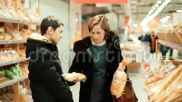 一个女人和她的儿子在商店买面包视频的预览图