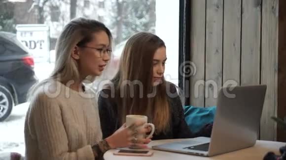 两个女孩在咖啡馆的笔记本电脑里工作视频的预览图