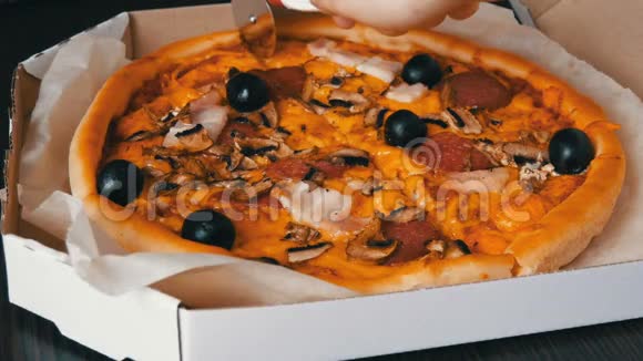 手切一块意大利大比萨饼里面有黑橄榄培根腊肠和奶酪视频的预览图