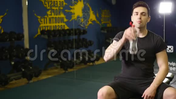 穿着运动服的年轻成年运动员在健身房用彩色塑料水瓶进行交叉配水视频的预览图
