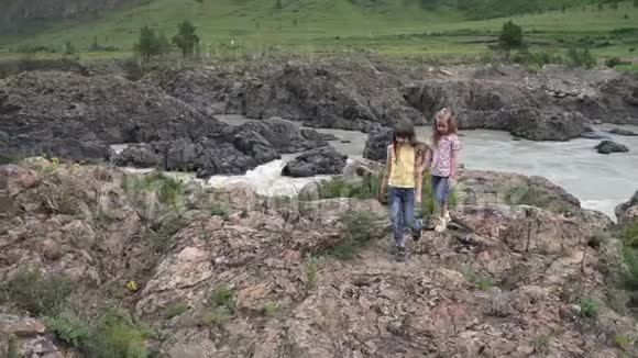 小妹妹旅行者女孩穿过群山牵着手视频的预览图