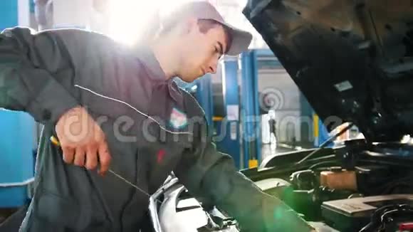 工作服的机械师检查汽车中的机油水平汽车维修视频的预览图