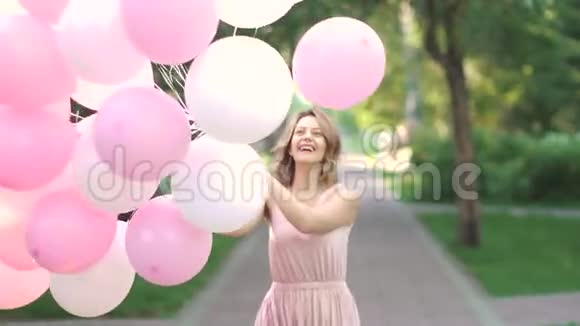 年轻女子高兴地旋转着拿着气球慢动作视频的预览图