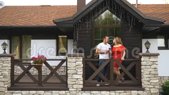快乐的一对相爱的夫妇喝着酒走上阳台视频的预览图