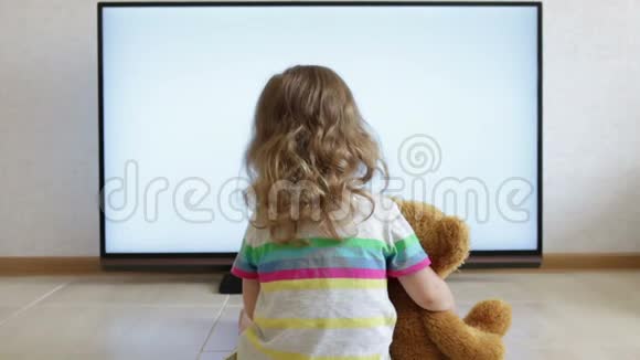 小孩子正坐在地板上看电视视频的预览图