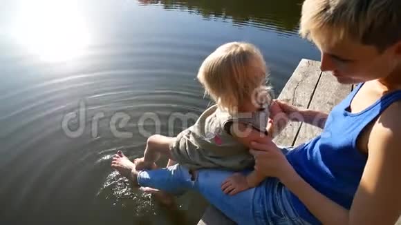 湖边的风景芦苇和母亲带着女儿在码头上视频的预览图