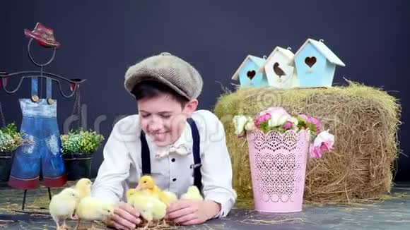 一个乡下人穿着时髦和小鸭子和小鸡玩耍背景是干草堆有颜色的鸟屋视频的预览图