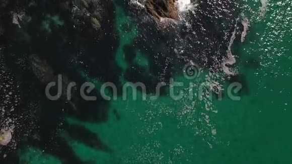 无人驾驶飞机的海浪拍打着岩石海岸的顶部视频的预览图