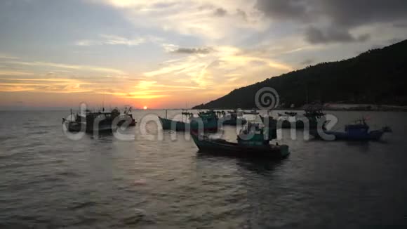在海滩上观看日落背景是越南传统渔船漂浮在风景秀丽的蓝海上视频的预览图