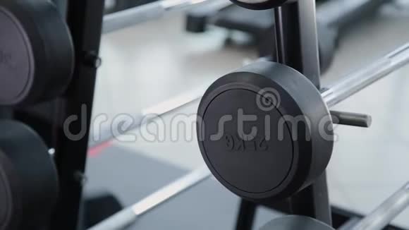 一组重量不同的重量在健身房的架子上视频的预览图
