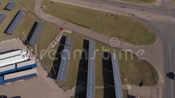 联合发电太阳能电池板和风车在道路上提供加油站和温室俯视空中无人机视频的预览图