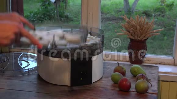 双手将盛满梨片的盘子放在水果烘干机上特写镜头4K视频的预览图