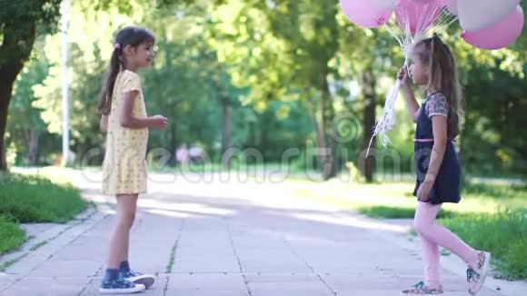 一个小女孩给你女朋友一束气球夏天公园的两个小妹妹视频的预览图