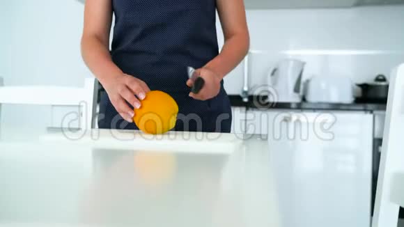 女人在现代化的厨房里切橘子视频的预览图