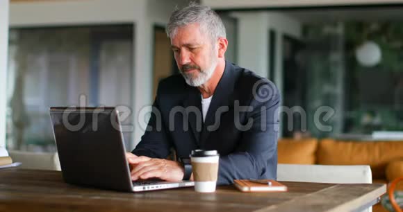 商务人员一边喝咖啡一边用笔记本电脑视频的预览图