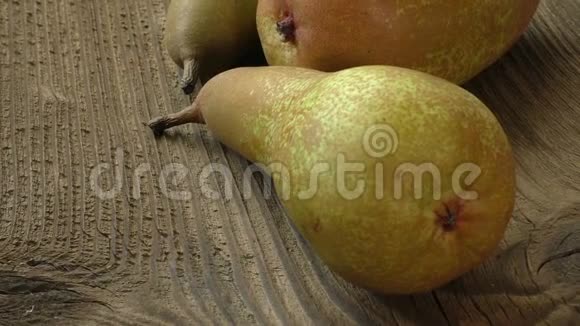 三个成熟多汁的梨子放在深色的木桌上视频的预览图