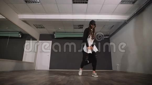 空工作室里的女人上舞蹈课她穿着一件免费的衬衫头上戴着一顶帽子视频的预览图