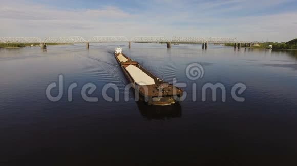 在桥的背景上装满沙子和砾石的驳船漂浮在宽阔的河流上空中景观视频的预览图