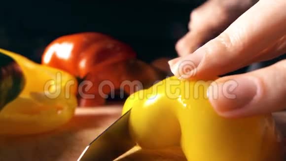 女人切多汁的黄色甜椒健康的饮食观念4K慢动作视频视频的预览图