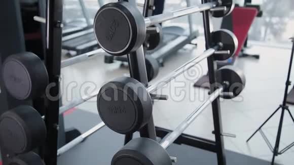 一组重量不同的重量在健身房的架子上视频的预览图
