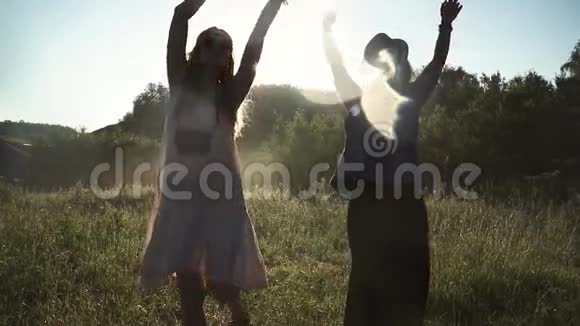 穿着嬉皮士服装的女孩在黎明时跳舞举起双手到顶端慢动作视频的预览图