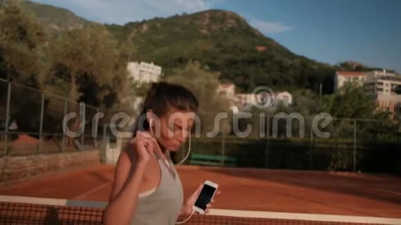 职业女运动员跳网球场听音乐视频的预览图
