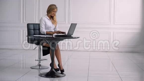 自信的女商人坐在桌子旁在笔记本电脑上打字视频的预览图