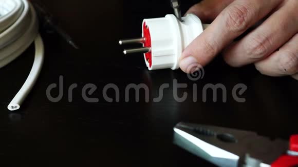 使用螺丝刀修理插头的电工视频的预览图