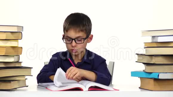 男孩坐在桌子旁翻阅着书白色背景视频的预览图