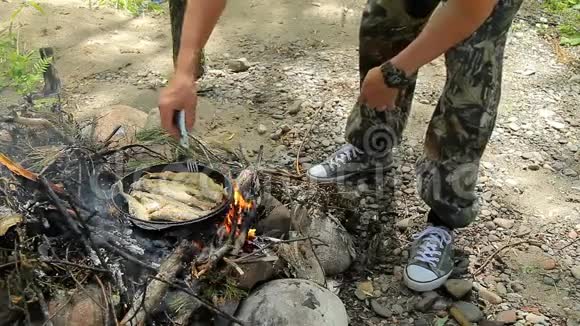 人在火上煎鱼炸淡水鱼格雷林火上煎锅里烤的鱼视频的预览图