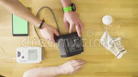 测量老年妇女血压的年轻人视频的预览图