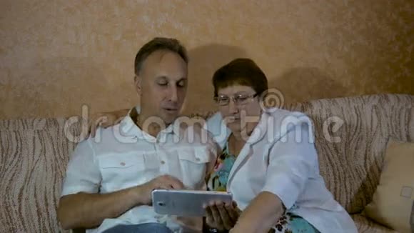 儿子教一位年迈的母亲使用平板电脑视频的预览图