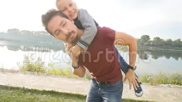 家庭和儿童的概念快乐父子在夏日公园玩得开心视频的预览图