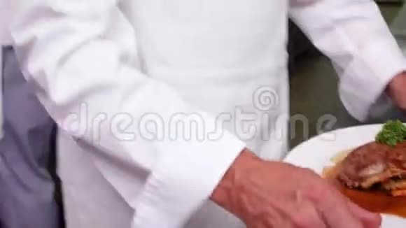 微笑的女服务员被厨师递给一道菜视频的预览图