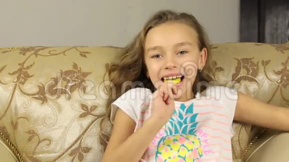 女孩以柠檬的形式在棍子上舔糖果竖起大拇指视频的预览图
