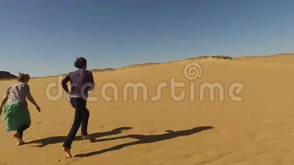 埃及沙漠中赤脚奔跑的夫妇视频的预览图