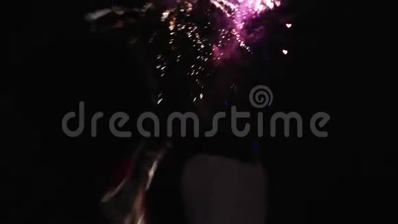 婚礼情侣的后侧侧影看着夜空中爆炸的烟火以心脏的形式出现视频的预览图