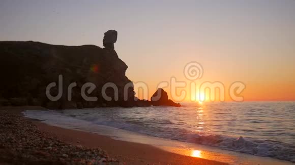 海滩上的日落与海面上金色的夕阳相映成趣波浪慢慢地溅在沙子上高清慢运动罪行视频的预览图