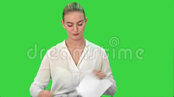 愤怒的年轻女子撕下一张纸把它扔到绿色屏幕上的相机上Chroma键视频的预览图