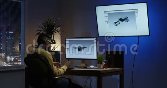 年轻人坐在电脑上编辑一个3D模型视频的预览图