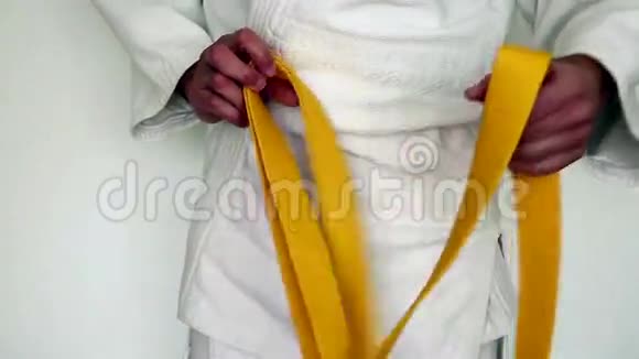 武术服装柔道男子收紧黄色腰带上的白色和服视频的预览图