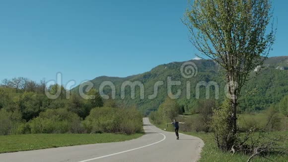 夏天年轻人骑着长板在乡间小路上视频的预览图