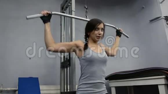 年轻女子在健身器材上锻炼肌肉视频的预览图