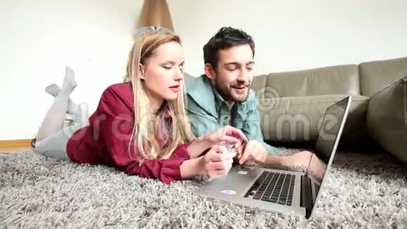 男人和女人躺在客厅的地毯上一边上网买东西视频的预览图