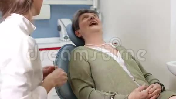 可爱的女牙医为老年女性病人做检查视频的预览图